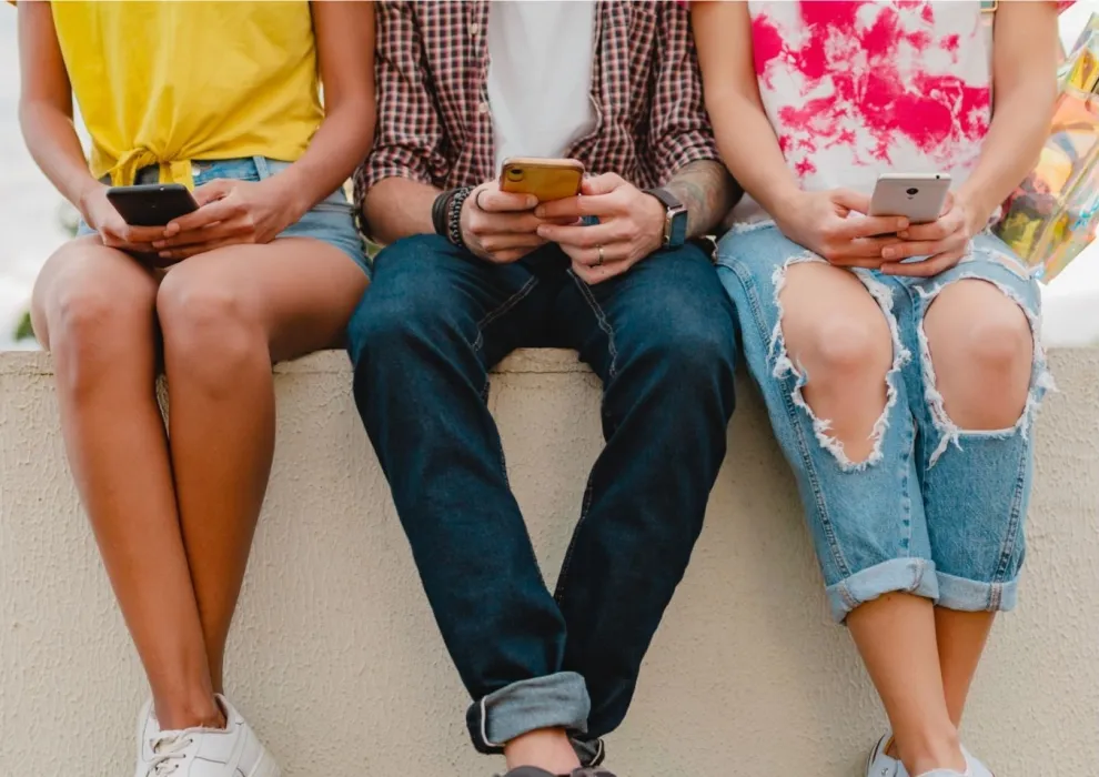 Imagen de adolescentes usando teléfono movil